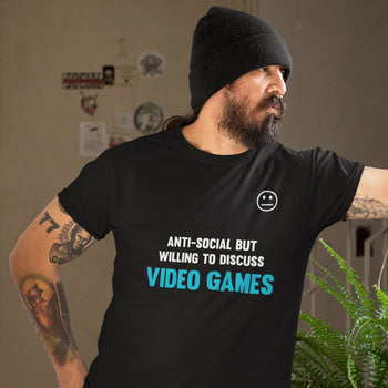 Man wearing funny gaming t-shirt with blank face emoticon and text saying 'Anti-social but willing to discuss video games'.