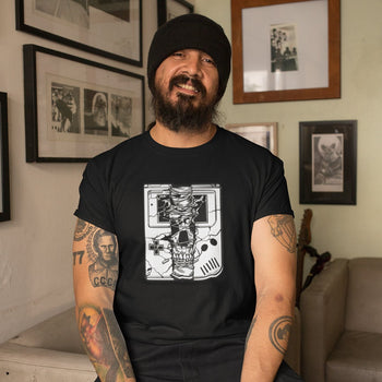 Man wearing horror-themed gaming t-shirt with an illustration of a skull emerging from within a Game Boy.